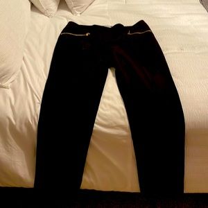 Black Calvin Klein dress pants with gold zippers and pockets